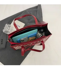 Spacious interior of red bow tote bag showing capacity for tablet, phone and umbrella