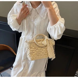 Detailansicht der handgefertigten Stroh-Eimertasche mit eleganter Spitze-Schleife