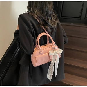 Pink Boston handbag featuring lace bow and pearl charms with double front pockets