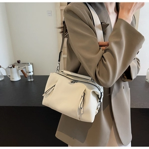 Detail of cream Boston bag with lychee texture and wide fabric shoulder strap