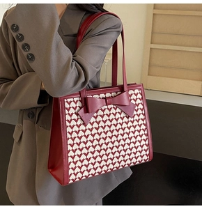 Detail of red bow on woven texture tote bag with leather straps for women