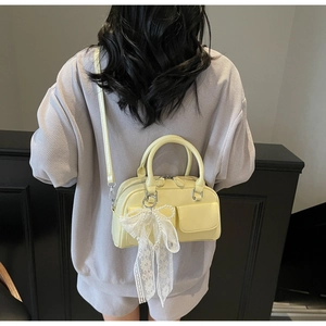 Mannequin portant un sac Boston jaune pâle avec nœud en dentelle et perle chic
