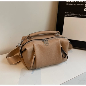 Detail of khaki pebbled leather crossbody bag with multiple zippers and wide strap