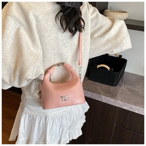 Detailed shot of pink leather crossbody bag with silver hardware and logo lettering