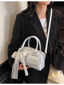 Sac bowling bleu clair verni avec nœud en dentelle et perles porté par mannequin