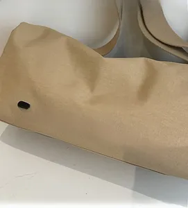 Close-up of light brown canvas bag with SHANGCAIBAG logo and durable woven strap
