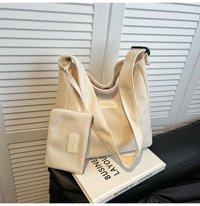 Detail of beige corduroy hobo tote bag with adjustable strap and small matching pouch