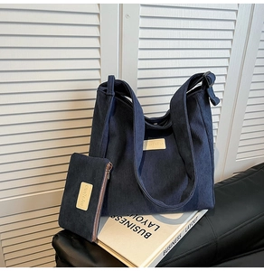 Detail of dark blue corduroy tote bag and matching pouch with textured fabric detail