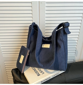 Detail of dark blue corduroy tote bag with small matching pouch and leather logo patch