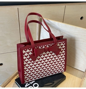 Detail of red bow tote bag featuring red and white heart-shaped woven texture