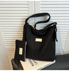 Detail of black corduroy tote bag set with small matching zipper pouch on table