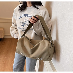Detail of olive green canvas crossbody bag with adjustable wide strap and side pocket