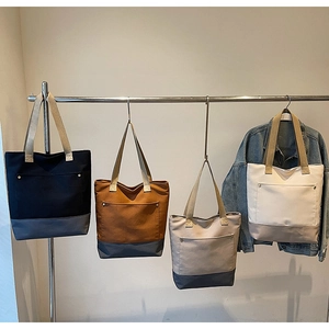 Detail of color-block canvas tote bags in four colors with metal buckle pocket and long straps