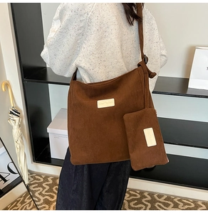 Close-up of brown corduroy tote bag with small matching pouch and signature label