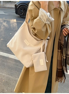 Close-up of beige corduroy tote bag with matching mini pouch in an autumn street setting