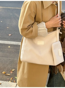 Detail view of corduroy tote bag texture and small matching pouch in street setting