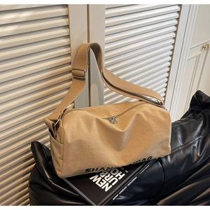 Close-up of khaki canvas pillow bag with metal zipper and adjustable wide shoulder strap