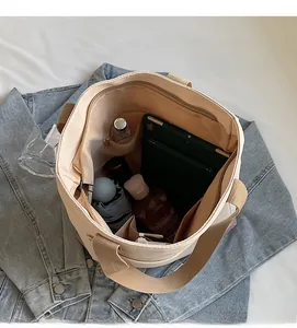 Top view of spacious canvas bucket bag interior with laptop, umbrella and inner pockets