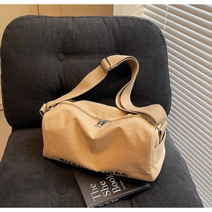 Detail of khaki canvas bag with double zipper and wide strap on corduroy seat