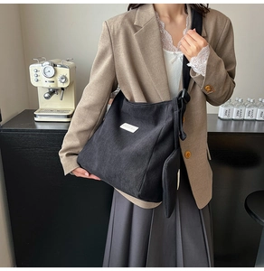 Detail of black corduroy tote bag and matching mini pouch for women's casual style