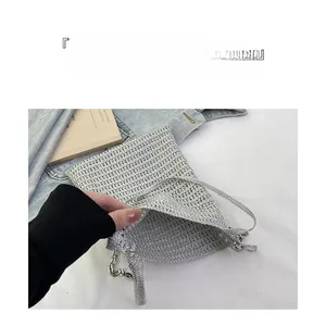 Detail of silver woven bucket bag with metallic chain and spacious open interior