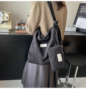 Detail of black corduroy hobo tote bag with matching coin purse and branding label
