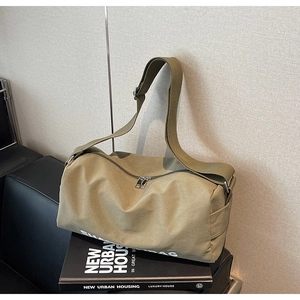 Detail view of army green canvas bag with dual silver zippers and adjustable strap