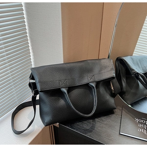 Detailansicht der schwarzen Tote-Bag aus genarbtem Leder mit elegantem Griff und feiner Naht