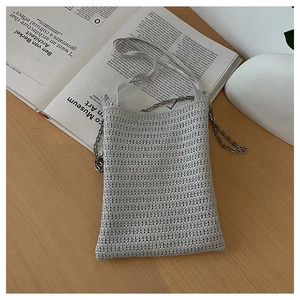 Detailed macro shot of silver-grey hand-woven texture and silver metal chain strap