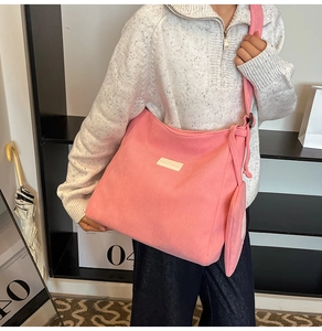 Detail of pink corduroy hobo tote bag with matching small pouch and adjustable strap