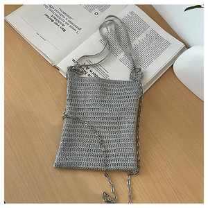 Detail of silver woven crochet phone bag featuring metallic texture and thin chain strap