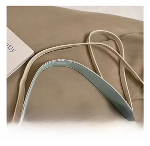 Détail de la poignée en cuir bleu clair et beige avec boucle en métal et nœud
