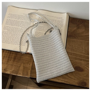 Detailed macro view of white crochet woven phone bag texture with silver chain and strap