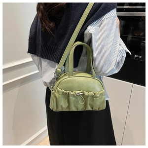 Detail of light green leather crossbody bag with pleated texture and metal buckle