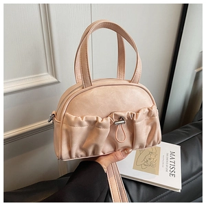 Detailed view of pink shell handbag with pleated leather texture and drawstring handle
