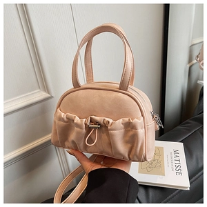 Detailed view of apricot mini handbag with ruffled texture and drawstring on art background