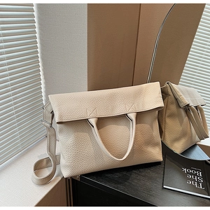 Detail der beigen Shopper-Tasche aus Leder mit litchi-Narbung und Griff