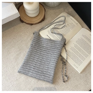 Close-up of silver-gray knit bucket bag featuring dual straps and metallic chain detail