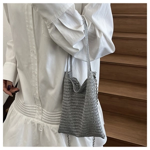 Detail of silver metallic woven bucket bag with fine mesh texture and slim chain strap