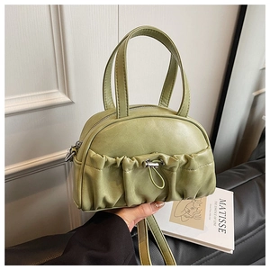 Close-up of green pleated pillow bag with metallic drawstring and soft leather texture