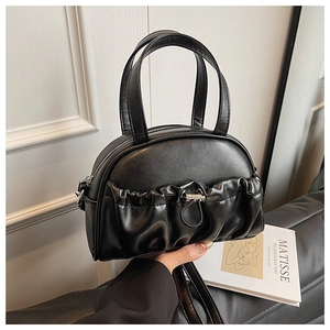 Close-up of black PU leather pillow bag featuring pleated pockets and silver drawstrings