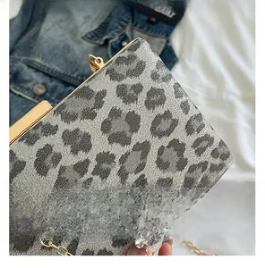Dettaglio della borsa da sera leopardata con cornice dorata e tracolla a catena