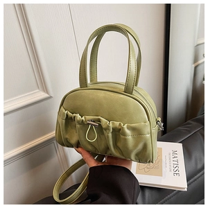 Detail view of grass green pleated leather handbag with drawstring and adjustable strap