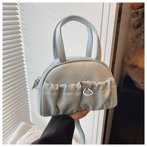 Detail shot of light blue mini bowling bag with ruched pocket and white elastic toggle