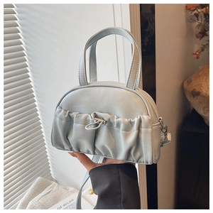 Detail of light blue pleated handbag showing silver clasp and elegant top handles