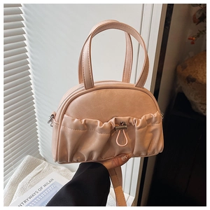 Detail of light pink shell handbag with pleated texture and stylish metal drawstring