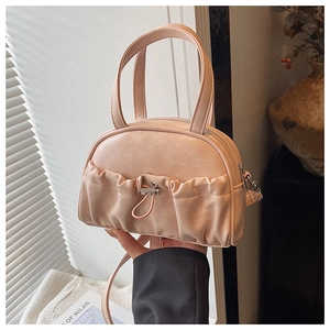 Detail of light pink mini handbag featuring unique ruched pocket and metallic hardware