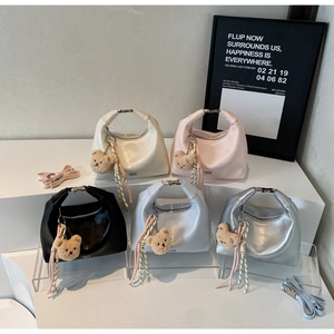 Collection of stylish crescent bags in white, pink, black, blue, and silver with charms