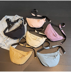 Detailed flat lay of nylon crescent dumpling bags in six colors on a wooden background