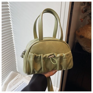 Detail of light green faux leather handbag with pleats and drawstring pocket
